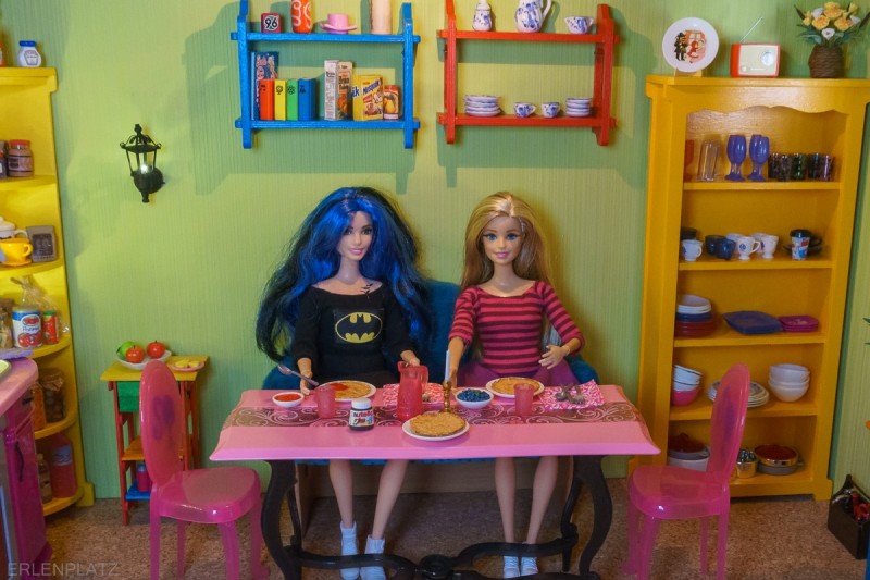 Die beiden Barbies Gloria und Barbie Meghan sitzen am Küchentisch mit leckeren Pfannkuchen, frischen Heidelbeeren und Nutella.